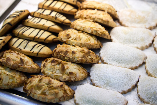 Assortment of delicious Sicilian pastries with almonds, chocolate drizzle, candied cherries and pistachio cream.