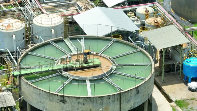 Aerial view captures a circular industrial water treatment pond with rotating clarifier equipment, representing water purification, process efficiency, resource management and sustainable industry.
