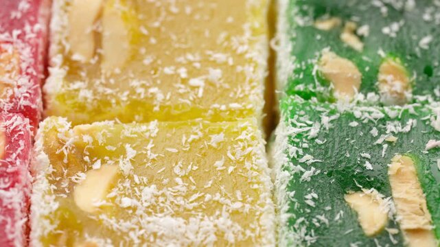 Assorted colorful Turkish delight sweets with nuts and coconut flakes rotating slowly close up. Rahat Lokum	
