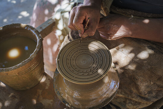 Potter's hands making a clay pot in a pottery workshop. No AI.