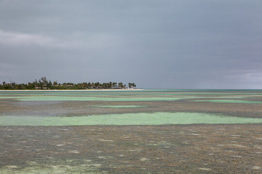 View of the shallow turquoise waters and coral reefs under a cloudy sky in Cayo Coco, Ciego de Avila, Cuba.