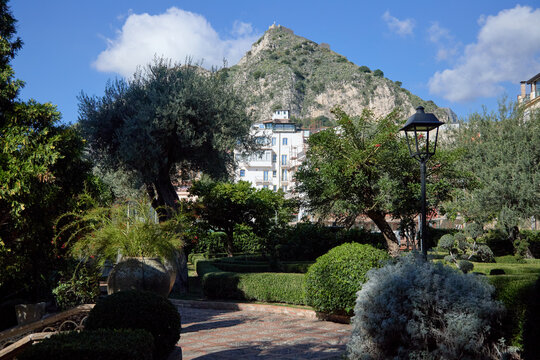 A picturesque view of the historic Villa Comunale park in Taormina, showcasing its unique architecture and vibrant botanical gardens