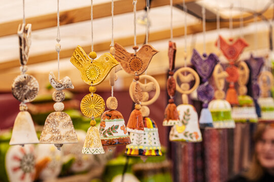 Colorful handmade ceramic bells hanging on display at a market or craft fair in Vilnius, Lithuania, Europe