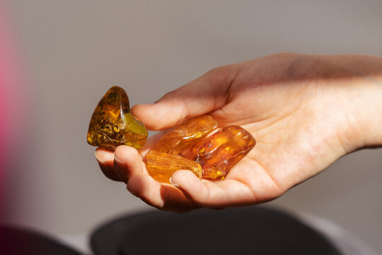 Big pieces of amber in the hand of a girl illuminated by sunlight