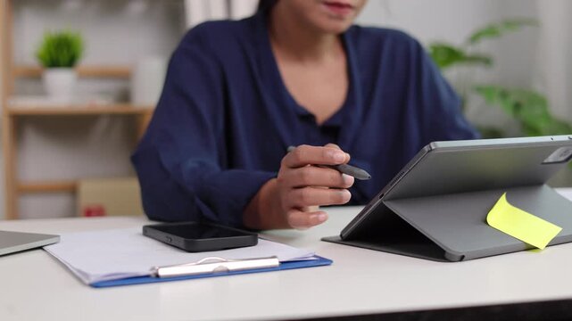 Close up hands of female manager drawing flowchart with electronic pencil on digital tablet glass surface while resting on white work table in spacious modern office room