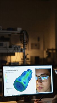 A computer screen displaying a 3D structural analysis for a plastic-free material bottle design in an engineering laboratory.