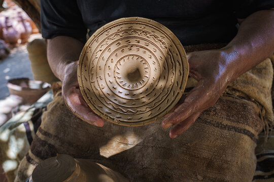 Potter's hands making a clay pot in a pottery workshop. No AI.