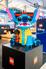 Obraz premium Bangkok, Thailand - September 4, 2026 : A large LEGO sculpture of Stitch from Disney Lilo & Stitch wearing sunglasses and a yellow shirt, holding a microphone.