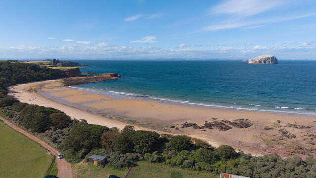 Panoramic view of Seacliff Beach sandy coastline with Bass Rock and Tantallon Castle Scotland