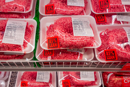 Packages of 85% lean ground beef on display in supermarket grocery store refrigerator case. Prices of ground beef have been rising.