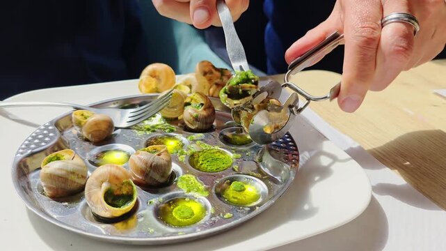 Father shows his young son how to remove a snail from its shell at a French restaurant, family dining moment, escargot lesson scene.