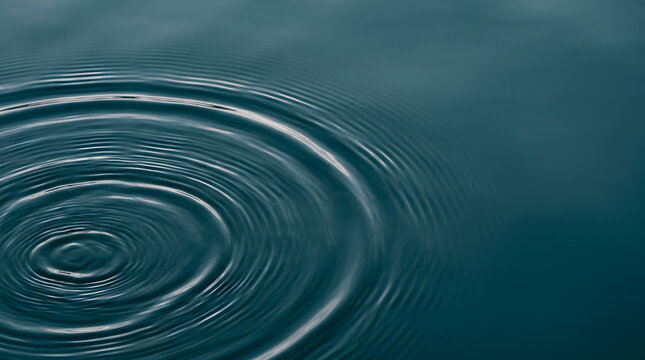Close-up of concentric teal water ripples on calm surface background