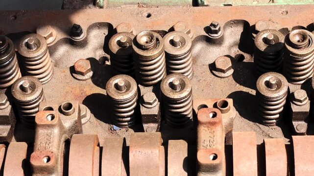 Top view panning shot of diesel cylinder head with exposed valve springs undergoes overhaul inside.