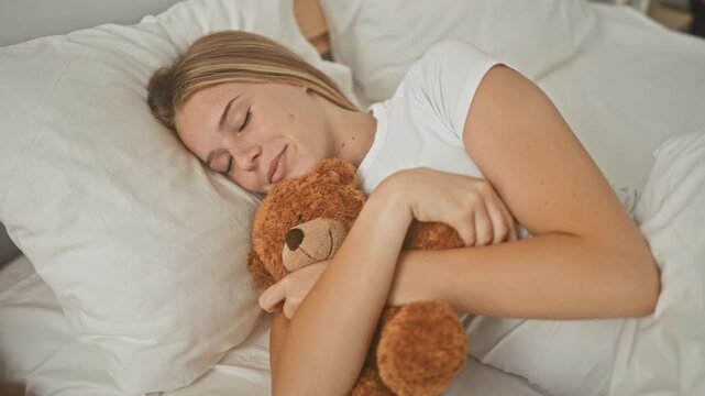 Young woman hugging a plush teddy bear, eyes closed, bare arms wrapped around the toy on a bed in a cozy bedroom; soft serenity.
