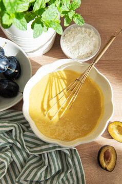 Baking plum cake ingredients with batter and flour
