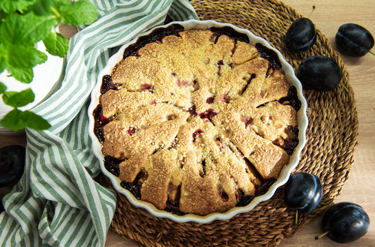 Baked plum dessert with crumb topping on rustic table