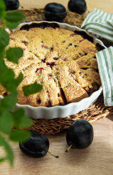 Baked plum dessert with crumb topping on rustic table