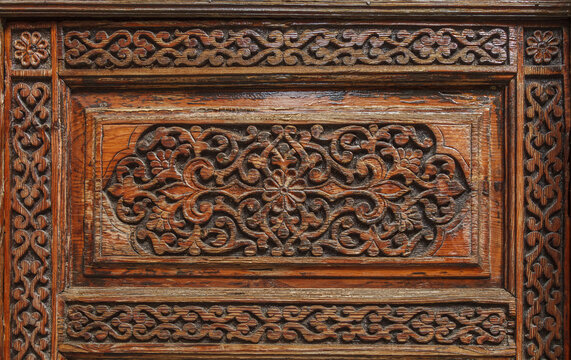 handmade carved wooden floral ornament with traditional geometric pattern, decorative texture from historic Uzbek architecture background