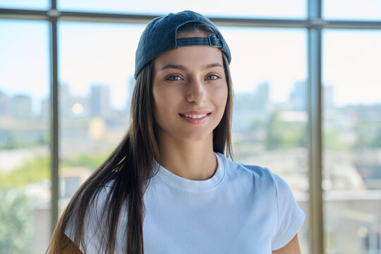 Close-up portrait of smiling young woman wearing backward cap