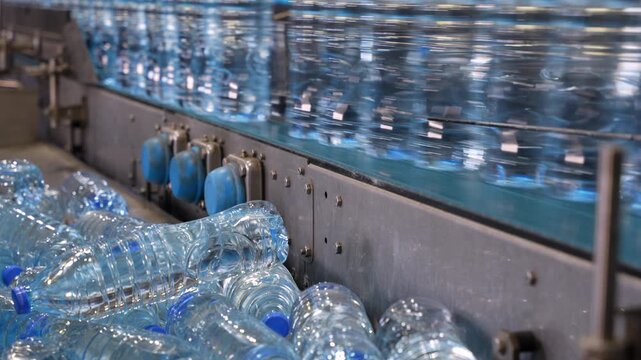 Deformed Plastic Water Bottles Beside Bottling Production Line