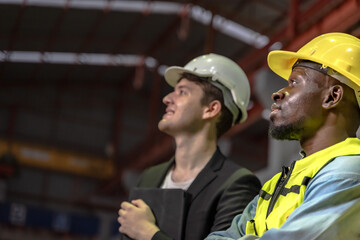 Portrait profile view of diverse male engineers or technicians thoughtfully looking into the distance in a modern industrial manufacturing plant background © Jack Tamrong