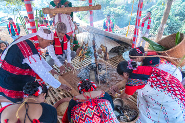 Mising elders kneeling around the sacred fire pit to place hands on the earth-mound, invoking blessings over roasted feast offerings during Ali-Aye-Lhigang in Guwahati,Assam,India on 19 february 2025. © Kulajit