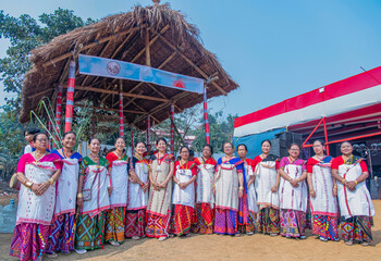 Mising women standing before the ceremonial thatched structure (Murong), dressed in vibrant during Ali-Aye-Lhigang at Sonaighuli in Guwahati,Assam,India on 19 february 2025. © Kulajit