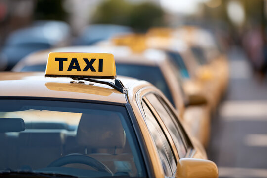 Close view of yellow taxis waiting in a line for passengers. Taxi fleet, urban transport, passenger service.