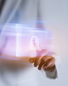 Hand of a professional touching a glowing digital folder with a lock symbol, featuring sleek glass textures and copy space for data security
