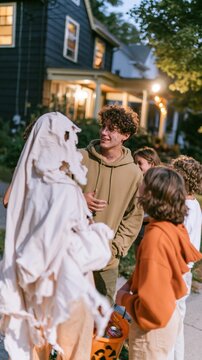 Mixed group of teenagers in face paint and hoodies on a halloween night, natural and unbothered for teen media and lifestyle ads