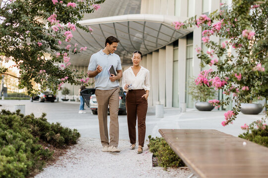 Couple enjoying a sunny day walk near blooming flowers in the city