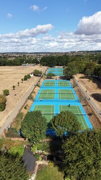 4K UHD vertical video drone shot overlooking the brand new tennis courts at Raphael Park, Romford, England. Sunny day with a clear sky and few clouds