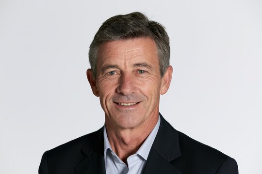 Cheerful mature businessman portrait with a confident smile against a clean white studio backdrop