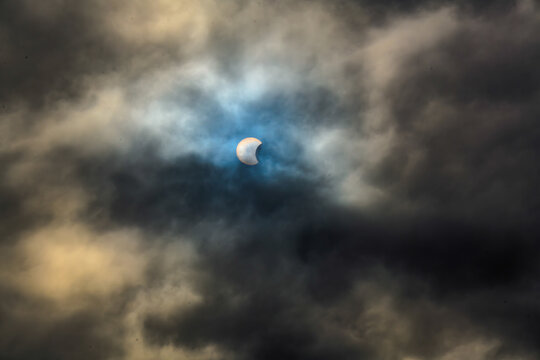&Eacute;clipse solaire partielle voil&eacute;e par des nuages dramatiques