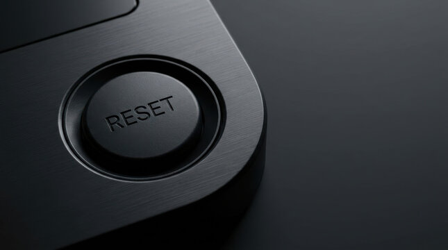 Reset button on black brushed metal control panel with dark background, symbolizing restart and technology concept