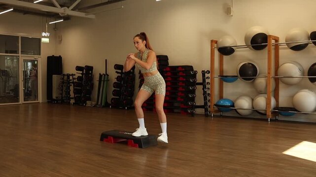 Woman performing standing exercise in gym, strength training, active lifestyle.