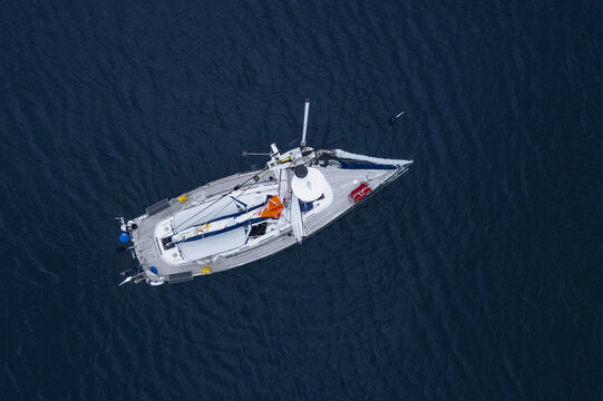 Isles, England - 07 June 2022: Aerial view of a sailboat sailing on dark blue water near St Martin's.