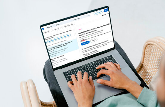 Person searching for job opportunities online using laptop