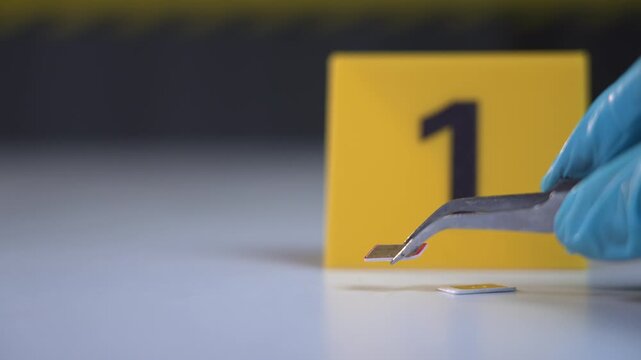 Gloved hand lifts a SIM card with tweezers beside evidence marker one on a white marble table, precise forensic investigation mood, focused close up shot