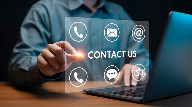 Businessman touching contact us virtual screen with communication icons and laptop on wooden desk
