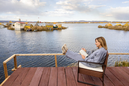 Slow travel moment with woman reading beside Lake Titicaca in Puno
