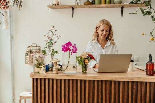 Female florist small business owner working on laptop