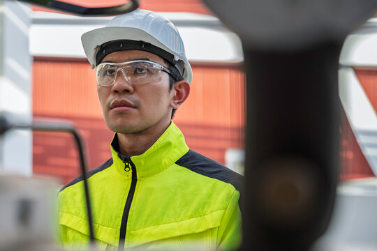 Industrial engineer inspects cooling water pipes at a large industrial facility. Concept of cooling system, engineering, thermal management, utilities, infrastructure, and plant operations.
