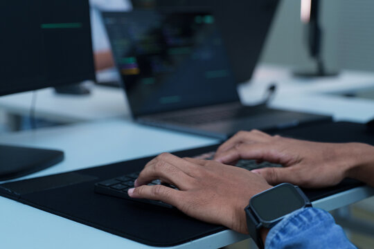 Programmer Typing Code on Laptop
