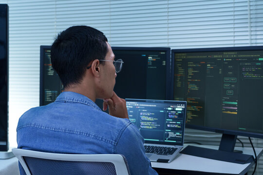 Programmer Developing Software with Multiple Code Screens