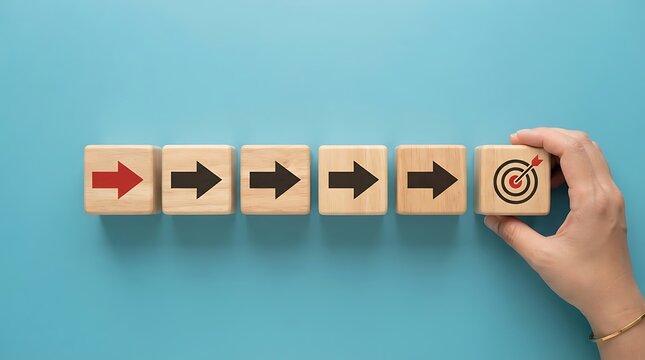 Hand placing a wooden block with a target icon to complete a sequence of arrows.