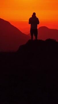 Silhouette of a man watching the sunrise over the mountains at Col d'Aubisque in France