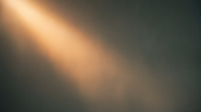 Soft golden light beam shining through dark grey smoke or mist in a moody atmosphere