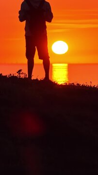 Soft focus view of a person moving across Dune du Pilat at sunset with the Atlantic Ocean beyond