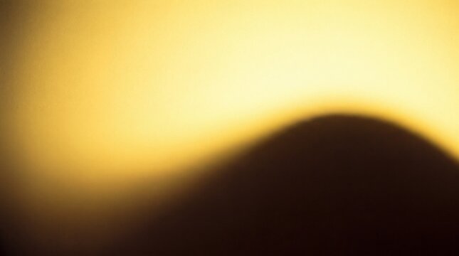 Soft yellow light gradient background, with a dark, blurred, curved silhouette, in the foreground